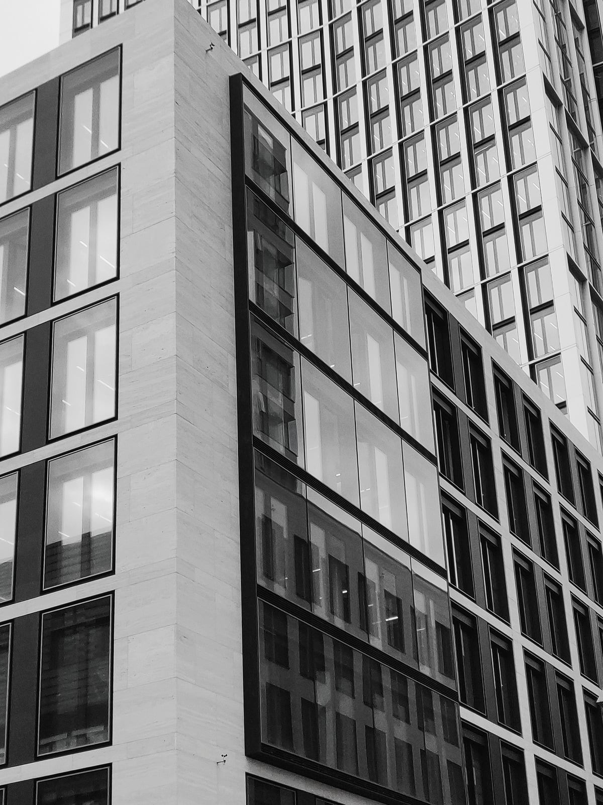 Black and white photograph of the stone and glass office facade.